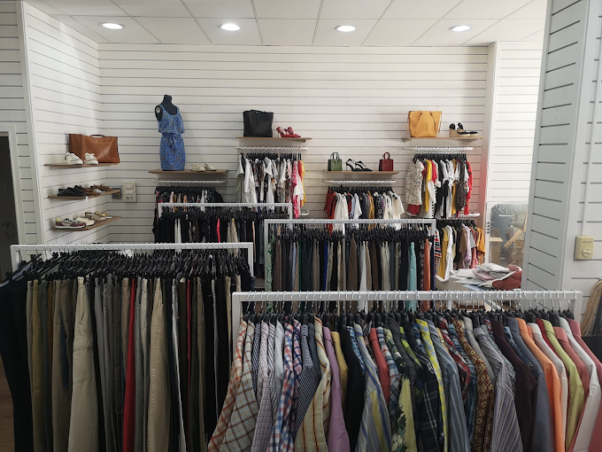 Racó de la Botiga Amiga amb penjadors de roba de colors i prestatges de sabates, simbolitzant l'economia circular al territori.